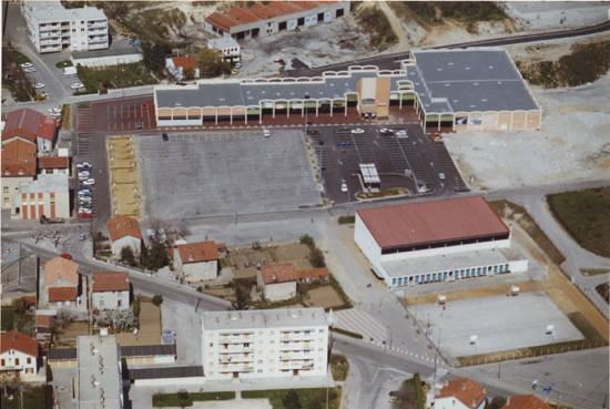 Vue aérienne du centre commercial, avec la mairie à gauche